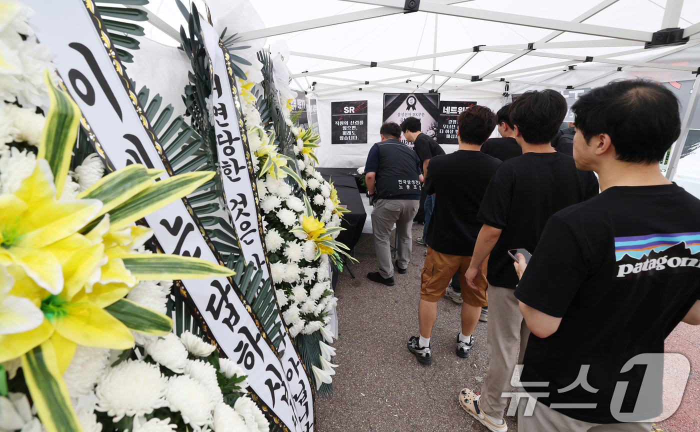 (수원=뉴스1) 김영운 기자 = 14일 경기 수원시 영통구 삼성전자 수원사업장 중앙문에서 열린 'DX부문 사기진작 및 보상마련 촉구 집회'에서 조합원들이 '2026 DX부문 사망선 …