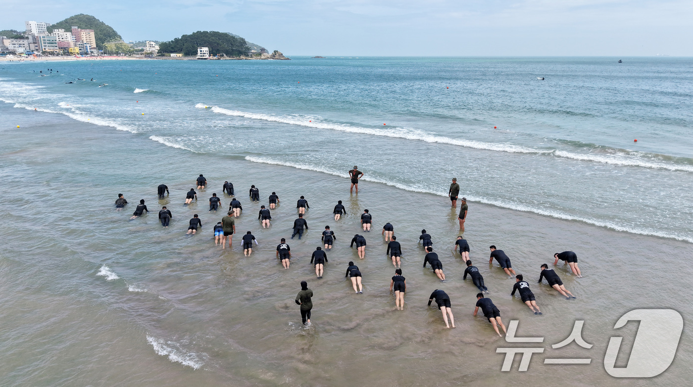 (부산=뉴스1) 윤일지 기자 = 삼복더위의 시작을 알리는 초복을 하루 앞둔 14일 부산 해운대구 송정해수욕장 53사단 해상훈련장에서 53사단 장교·부사관들이 '송정해상훈련 교관 집 …