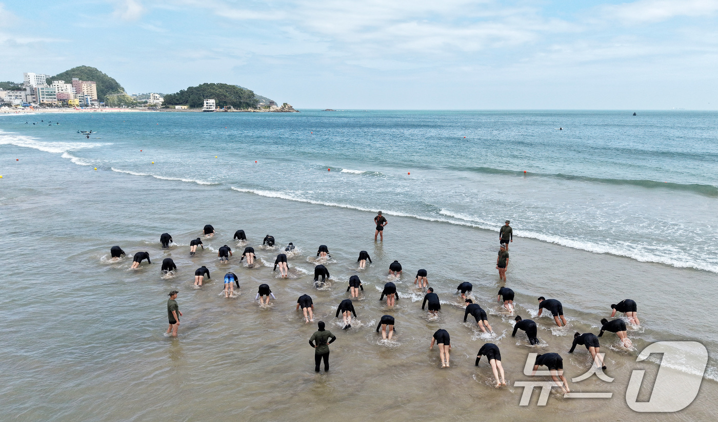(부산=뉴스1) 윤일지 기자 = 삼복더위의 시작을 알리는 초복을 하루 앞둔 14일 부산 해운대구 송정해수욕장 53사단 해상훈련장에서 53사단 장교·부사관들이 '송정해상훈련 교관 집 …
