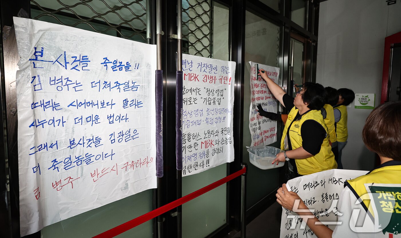 본문 이미지 - 마트산업노조 홈플러스지부 조합원들이 14일 서울 강서구 홈플러스 본사 입구에서 MBK의 일방적 면담 취소 규탄 및 노조 입장발표 기자회견을 마치고 본사에 항의하는 내용을 담은 대자보를 붙이고 있다. 2026.7.14 ⓒ 뉴스1 김도우 기자
