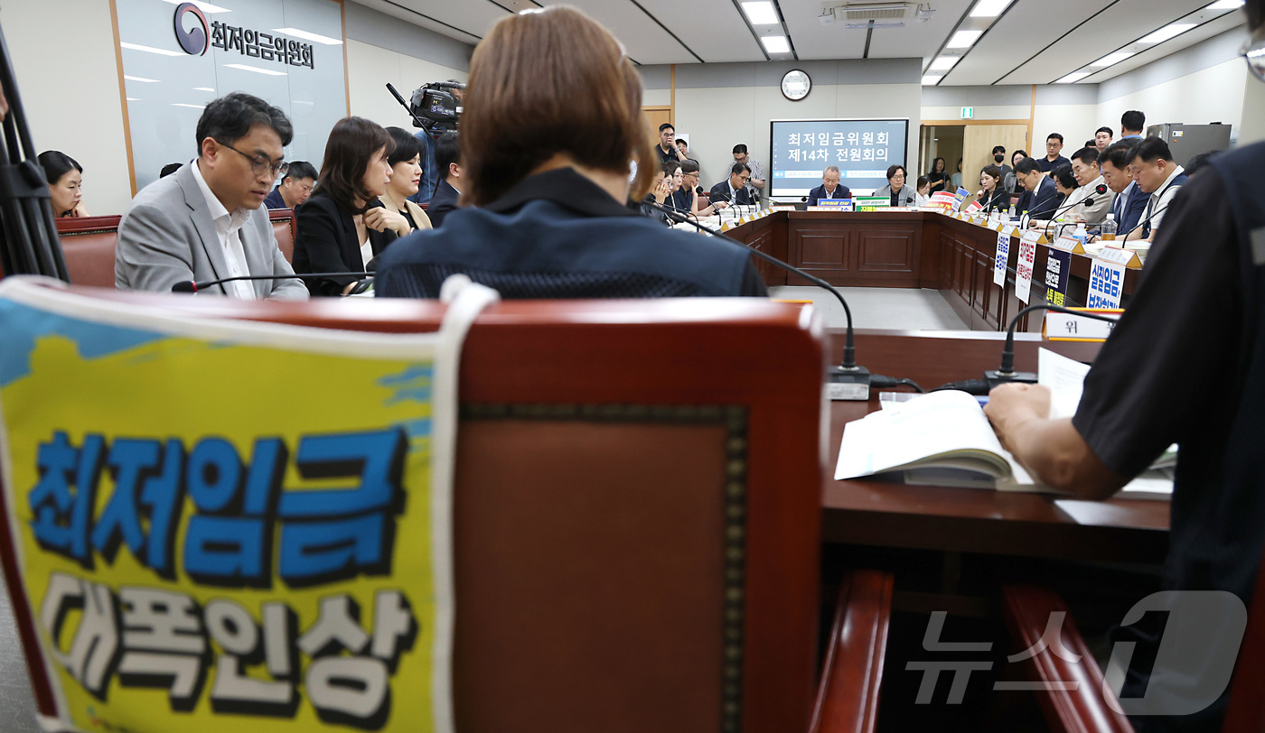 (세종=뉴스1) 김기남 기자 = 14일 세종시 정부세종청사 최저임금위원회에서 열린 2027년도 최저임금위원회 14차 전원회의를 시작하며 최저임금 대폭인상 손팻말을 게시한 근로자위원 …