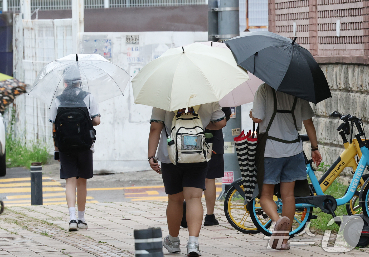(수원=뉴스1) 김영운 기자 = 14일 경기 수원시의 한 도로에서 학생들이 우산을 쓰고 하교를 하고 있다.기상청에 따르면 이날 밤부터 15일 새벽 사이 중부지방과 전라권을 중심으로 …
