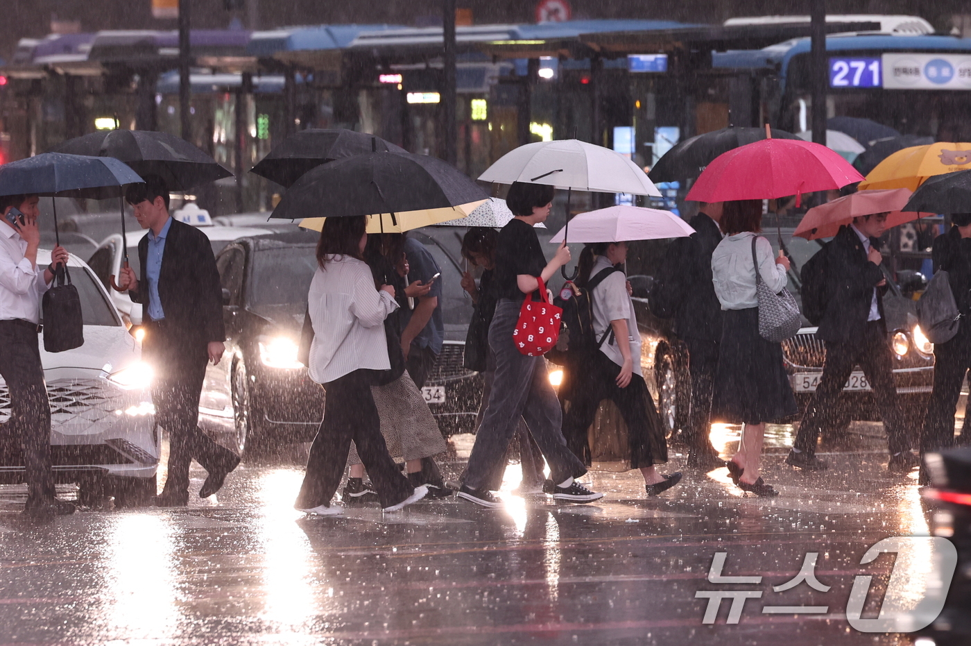 (서울=뉴스1) 구윤성 기자 = 수도권 곳곳에 호우주의보가 내려진 14일 오후 서울 종로구 광화문 네거리에서 시민들이 강한 빗줄기 속 퇴근길 발걸음을 재촉하고 있다. 2026.7. …