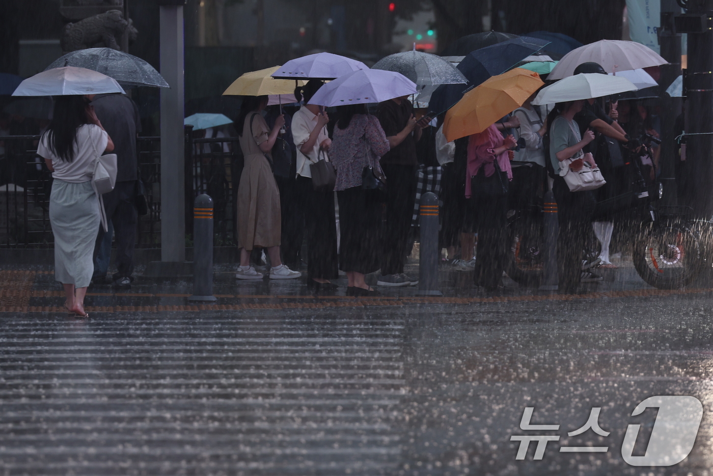 (서울=뉴스1) 구윤성 기자 = 수도권 곳곳에 호우주의보가 내려진 14일 오후 서울 종로구 광화문 네거리에서 시민들이 강한 빗줄기 속 퇴근길 발걸음을 재촉하고 있다. 2026.7. …