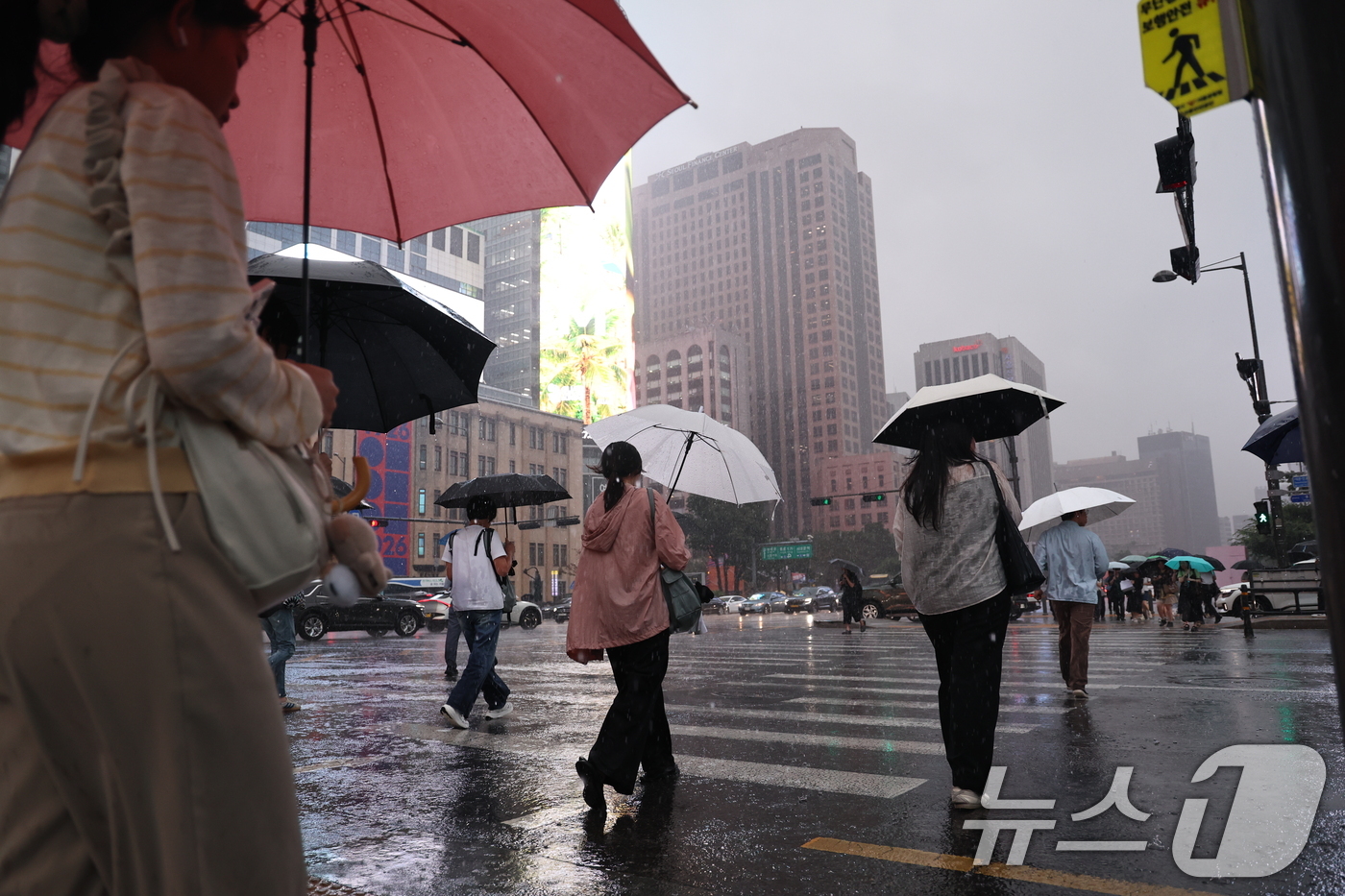 (서울=뉴스1) 구윤성 기자 = 수도권 곳곳에 호우주의보가 내려진 14일 오후 서울 종로구 광화문 네거리에서 시민들이 강한 빗줄기 속 퇴근길 발걸음을 재촉하고 있다. 2026.7. …