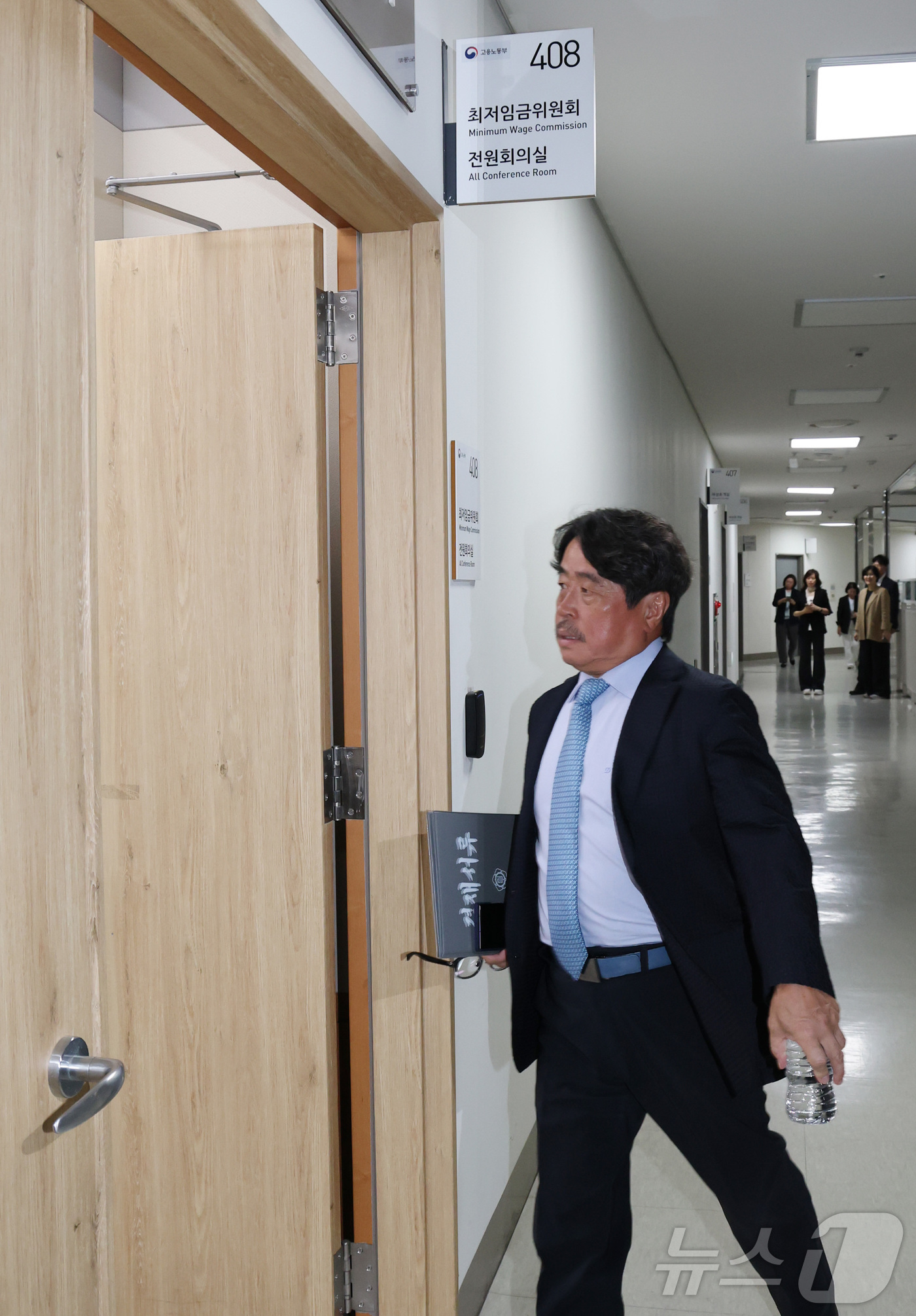 (세종=뉴스1) 김기남 기자 = 권순원 최저임금위원회 위원장이 14일 세종시 정부세종청사 최저임금위원회에서 열린 2027년도 최저임금위원회 14차 전원회의중 정회 시간을 마치고 회 …