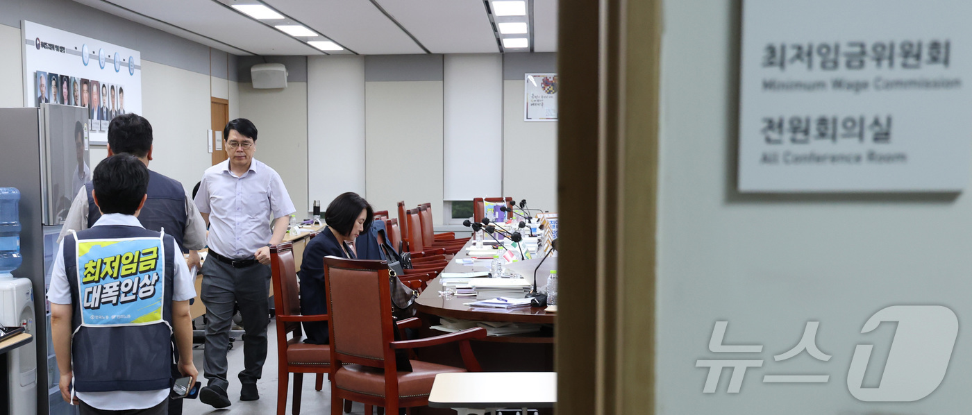 (세종=뉴스1) 김기남 기자 = 14일 세종시 정부세종청사 최저임금위원회에서 열린 2027년도 최저임금위원회 14차 전원회의가 정회된 시간에 위원들이 이동하고 있다.  2026.7 …