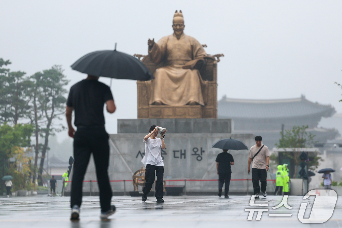 (서울=뉴스1) 안은나 기자 = 수도권에 100㎜의 비가 예보되는 등 전국에 장맛비가 내리는 15일 오전 서울 종로구 광화문광장에서 시민들이 출근길을 재촉하고 있다. 2026.7. …