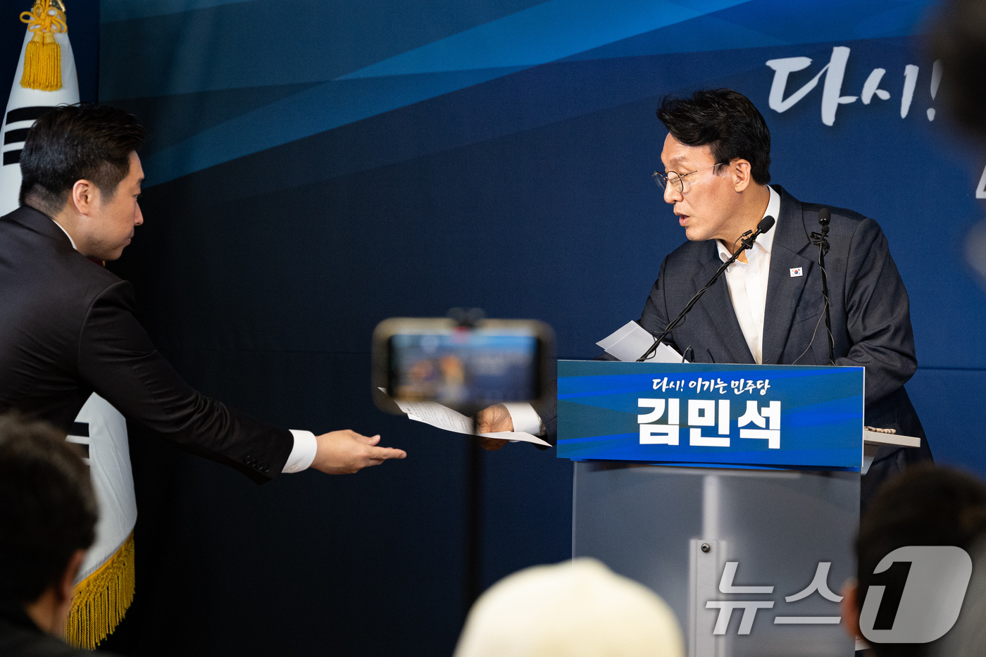 (서울=뉴스1) 유승관 기자 = 더불어민주당 당권 도전에 나선 김민석 전 총리가 15일 서울 여의도 민주당사 당원존에서 4대 혁신안 발표 중 김용만 의원으로부터 수정 원고를 건네 …