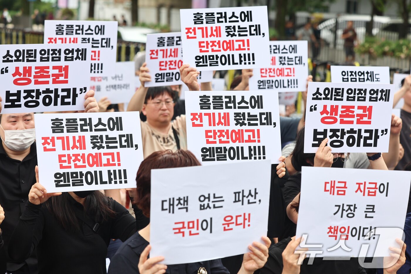 본문 이미지 - 홈플러스 입점 점주 협의회 회원들이 15일 서울 종로구 청와대 앞에서 생존권 촉구 집회를 열고 정부에 대책 마련을 촉구하며 피켓을 들고 있다. 2026.7.15 ⓒ 뉴스1 김도우 기자