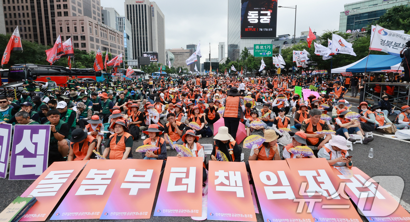 (서울=뉴스1) 이호윤 기자 = 민주노총 조합원들이 15일 서울 종로구 동화면세점 앞에서 열린 7·15 총파업대회에서 피켓을 들고 있다. 2026.7.15/뉴스1