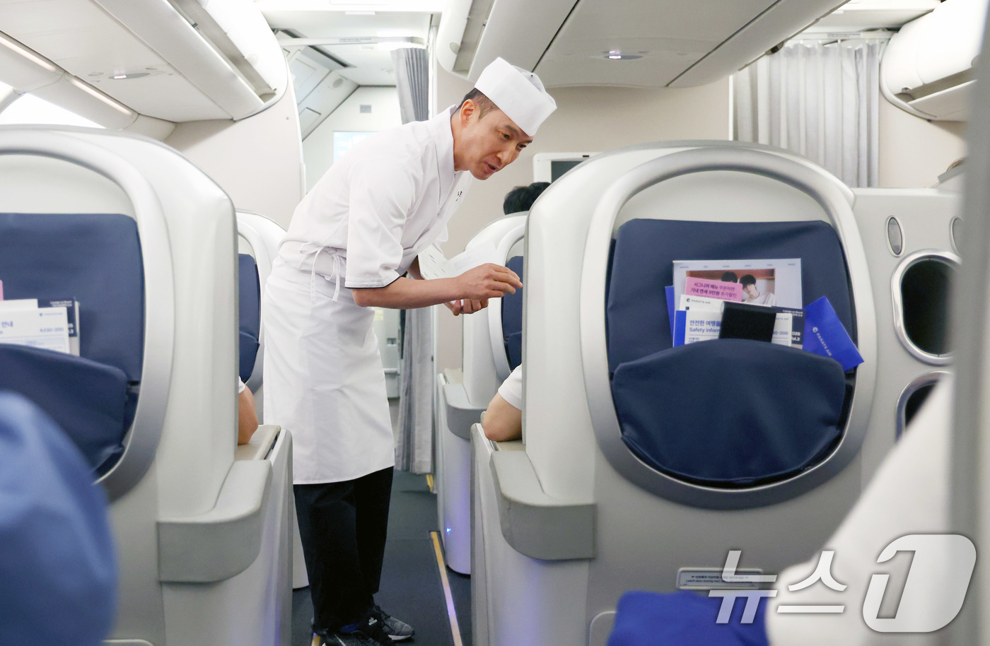 (인천공항=뉴스1) 공항사진기자단 = 파라타항공 신규 기내식 개발에 참여한 최규덕 셰프가 지난 15일 하노이행 항공편 기내에서 승객들에게 기내식 메뉴를 설명하고 있다.파라타항공은 …