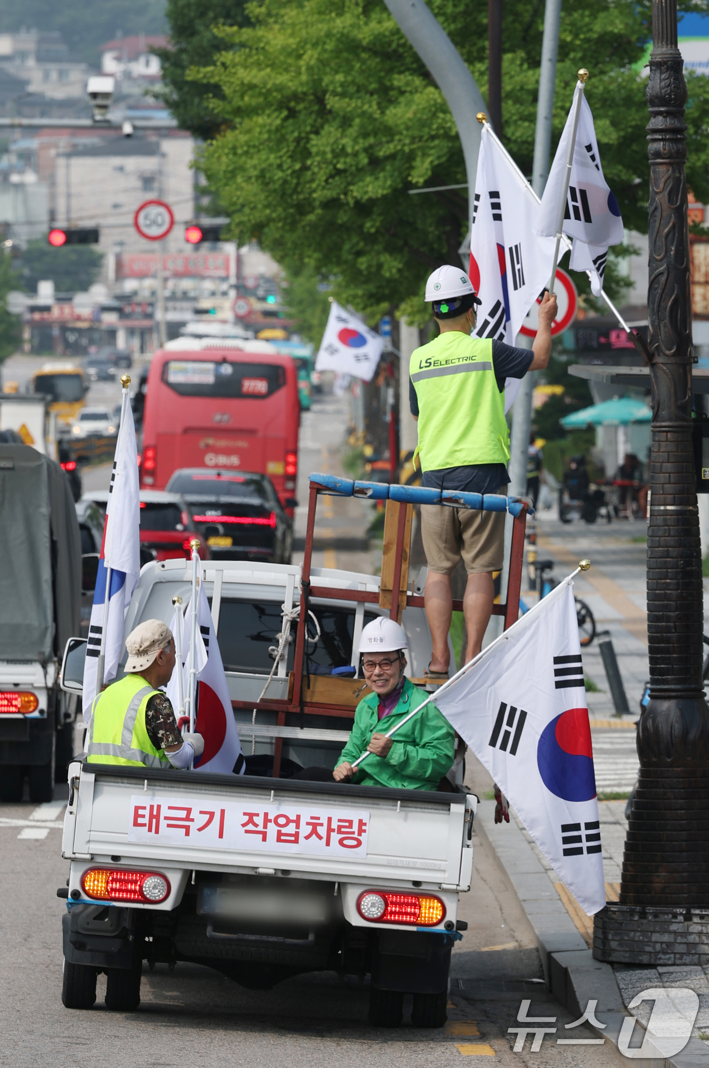 (수원=뉴스1) 김영운 기자 = 제78주년 제헌절을 하루 앞둔 16일 경기 수원시 장안구 관내에서 영화동 새마을지도자협의회 회원들이 태극기를 게양하고 있다.이날 게양한 태극기는 장 …