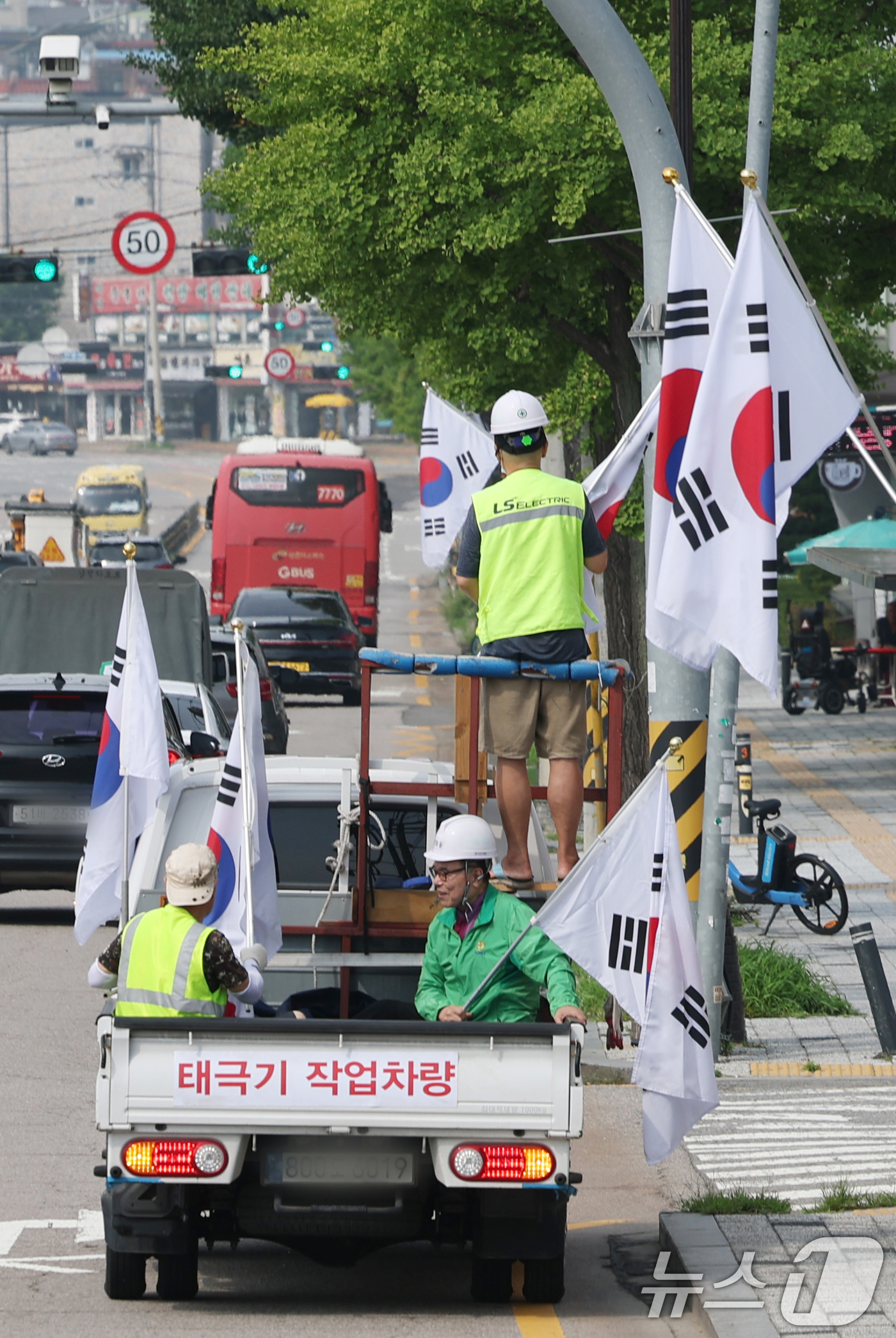 (수원=뉴스1) 김영운 기자 = 제78주년 제헌절을 하루 앞둔 16일 경기 수원시 장안구 관내에서 영화동 새마을지도자협의회 회원들이 태극기를 게양하고 있다.이날 게양한 태극기는 장 …