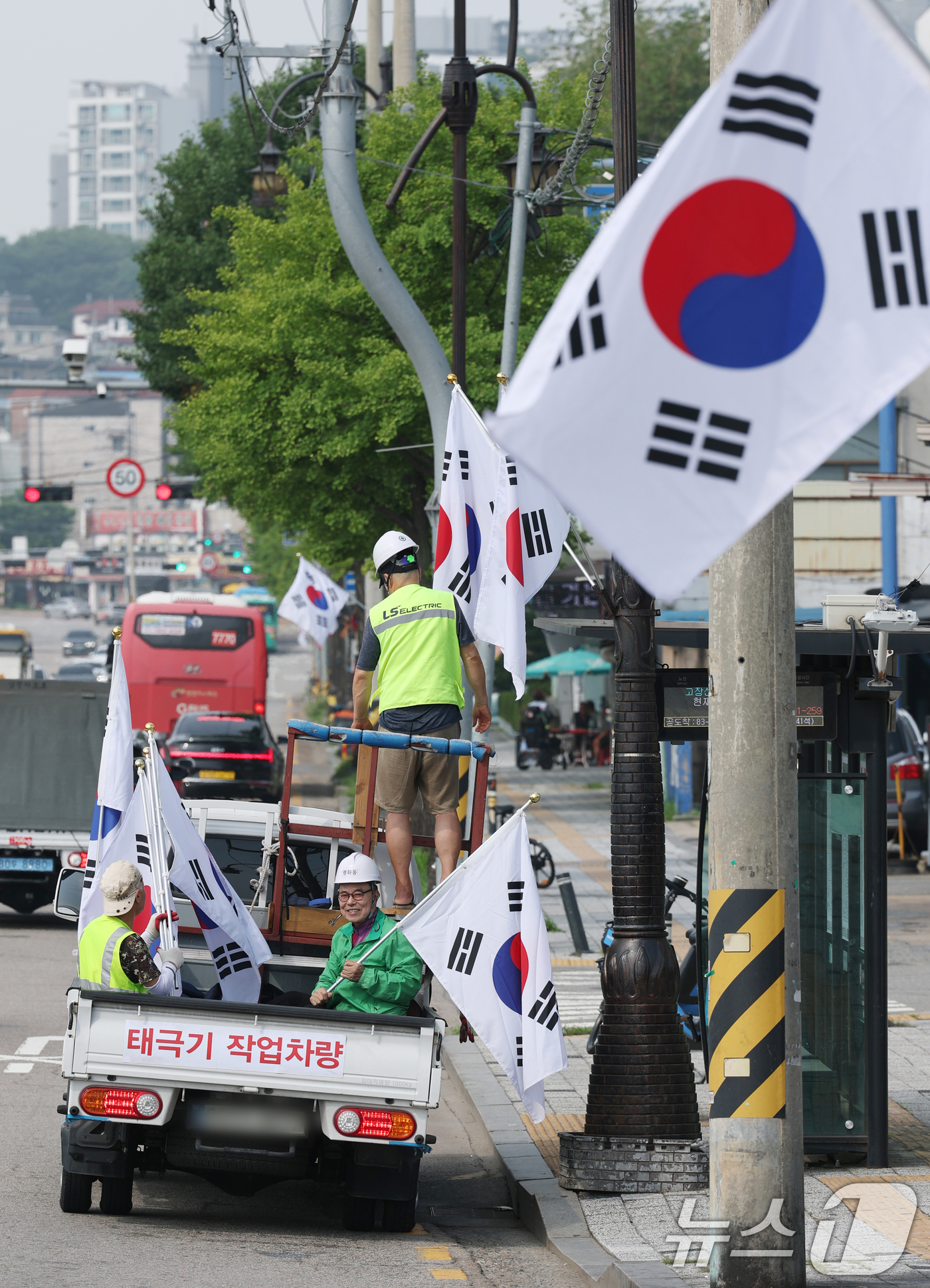 (수원=뉴스1) 김영운 기자 = 제78주년 제헌절을 하루 앞둔 16일 경기 수원시 장안구 관내에서 영화동 새마을지도자협의회 회원들이 태극기를 게양하고 있다.이날 게양한 태극기는 장 …