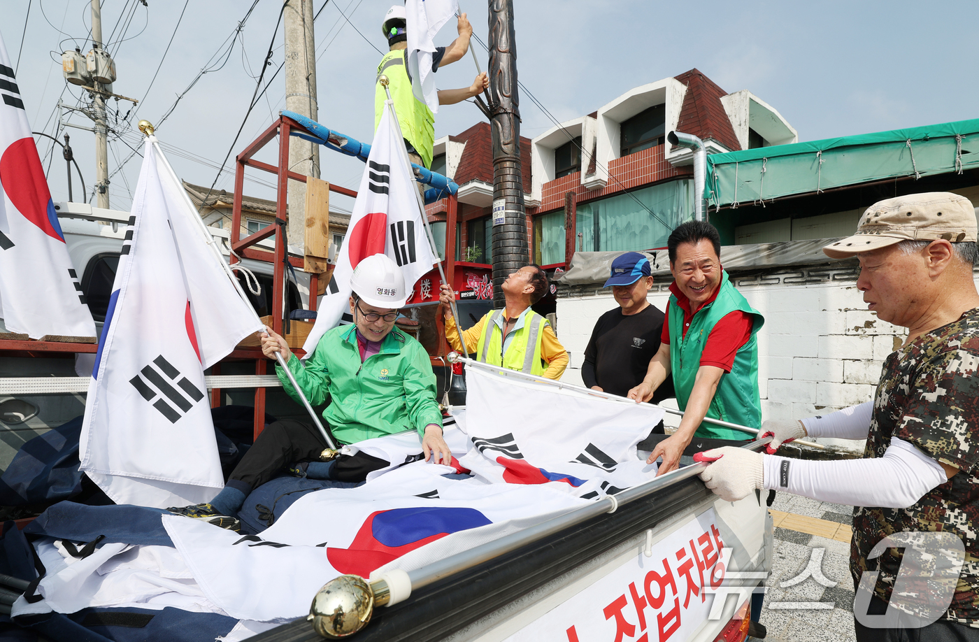 (수원=뉴스1) 김영운 기자 = 제78주년 제헌절을 하루 앞둔 16일 경기 수원시 장안구 관내에서 영화동 새마을지도자협의회 회원들이 태극기를 게양하고 있다.이날 게양한 태극기는 장 …