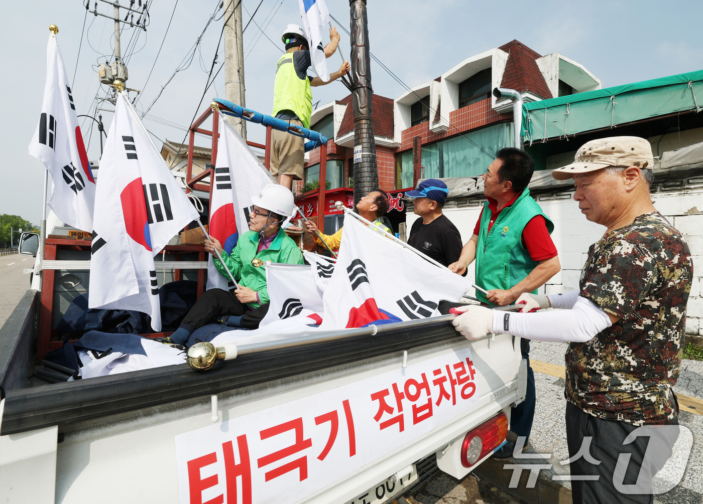 (수원=뉴스1) 김영운 기자 = 제78주년 제헌절을 하루 앞둔 16일 경기 수원시 장안구 관내에서 영화동 새마을지도자협의회 회원들이 태극기를 게양하고 있다.이날 게양한 태극기는 장 …