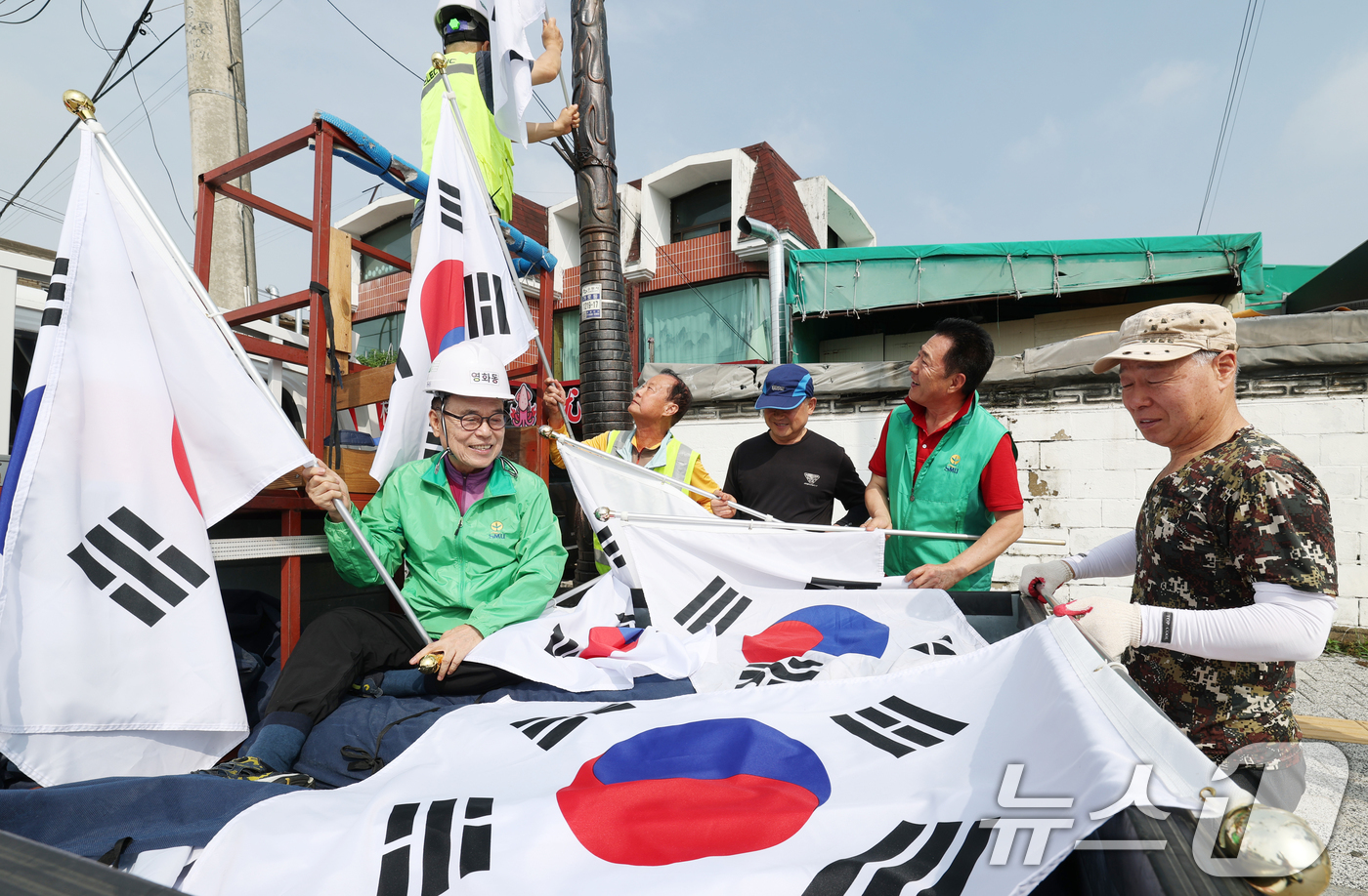 (수원=뉴스1) 김영운 기자 = 제78주년 제헌절을 하루 앞둔 16일 경기 수원시 장안구 관내에서 영화동 새마을지도자협의회 회원들이 태극기를 게양하고 있다.이날 게양한 태극기는 장 …