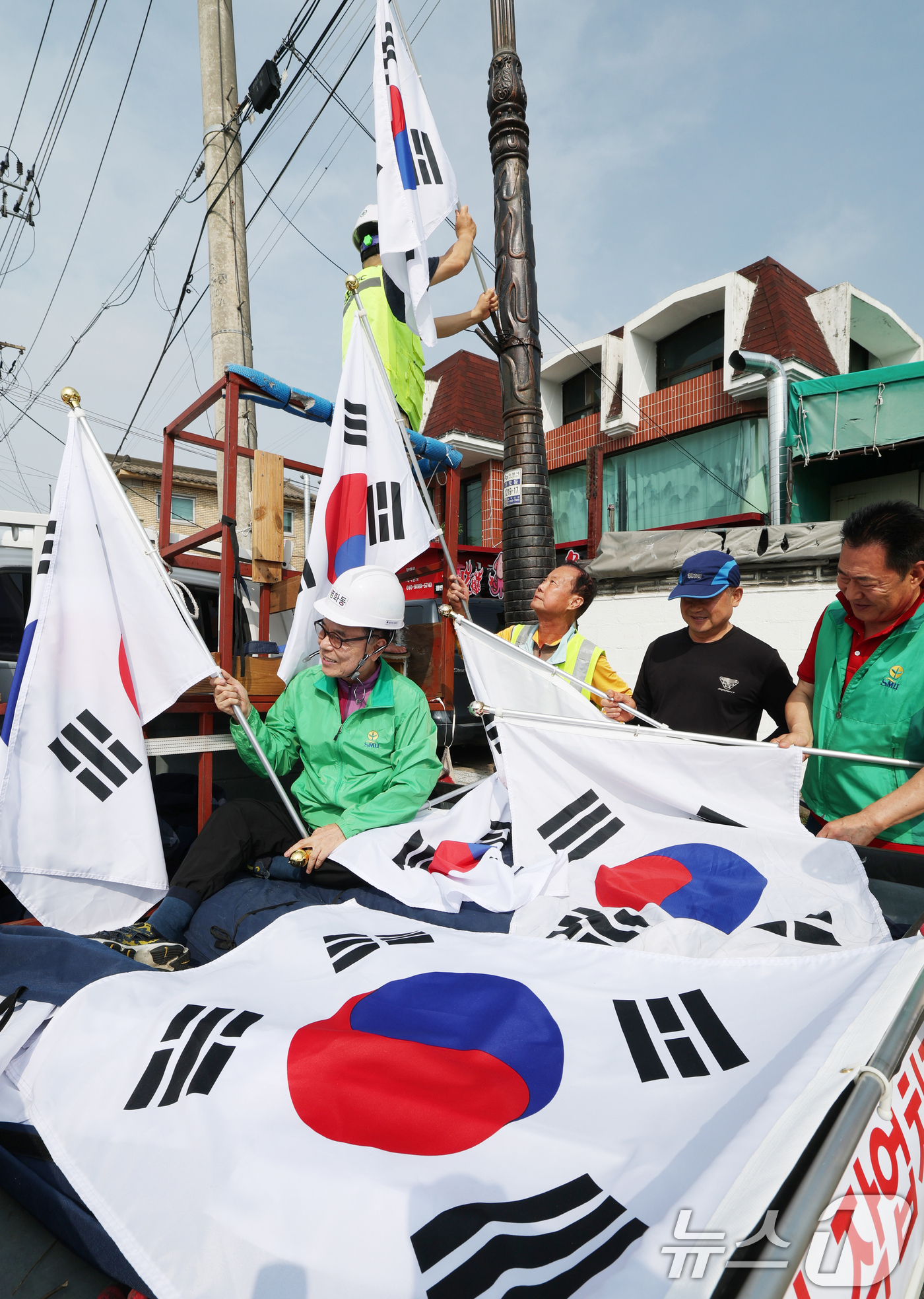 (수원=뉴스1) 김영운 기자 = 제78주년 제헌절을 하루 앞둔 16일 경기 수원시 장안구 관내에서 영화동 새마을지도자협의회 회원들이 태극기를 게양하고 있다.이날 게양한 태극기는 장 …