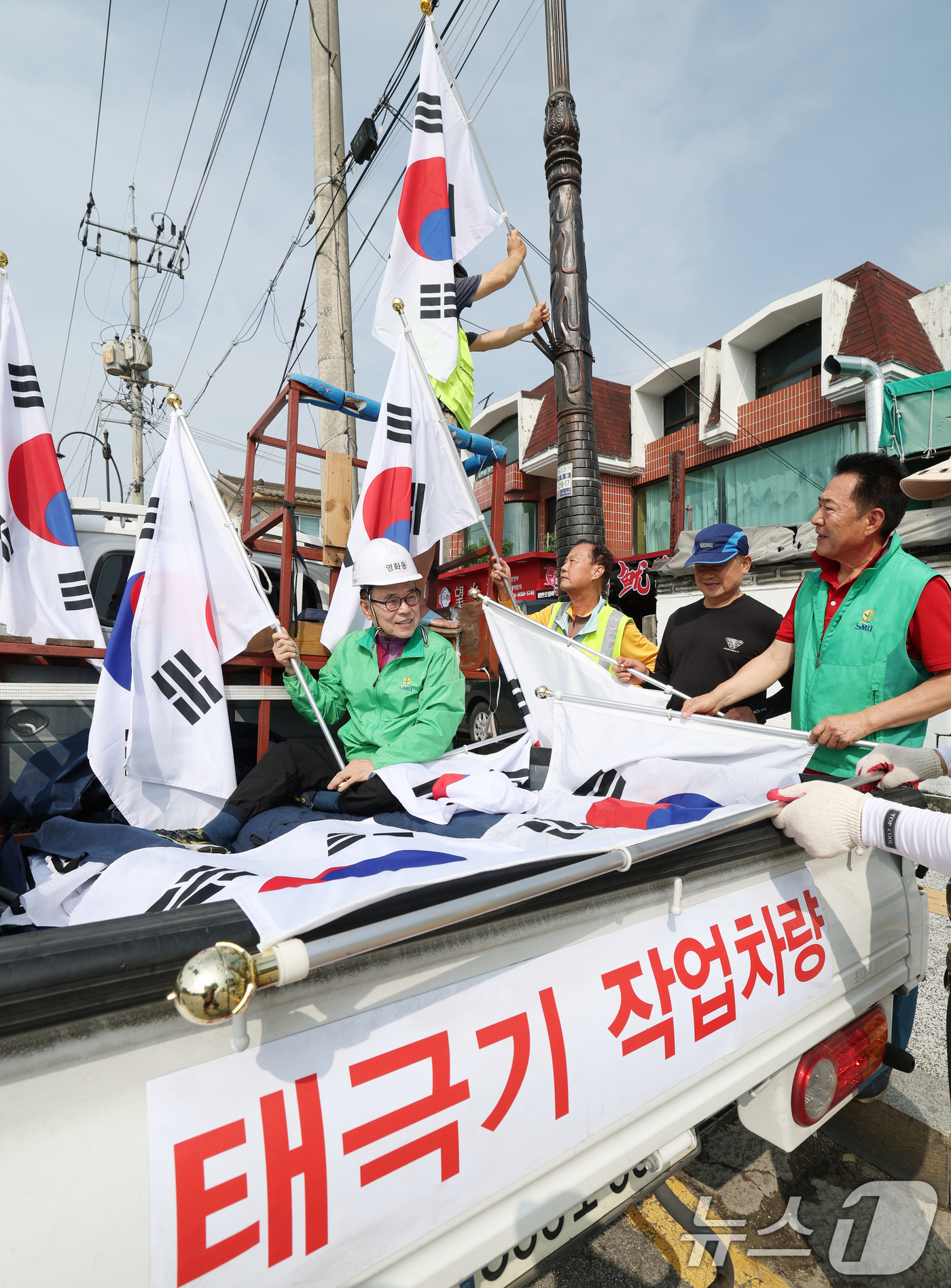(수원=뉴스1) 김영운 기자 = 제78주년 제헌절을 하루 앞둔 16일 경기 수원시 장안구 관내에서 영화동 새마을지도자협의회 회원들이 태극기를 게양하고 있다.이날 게양한 태극기는 장 …