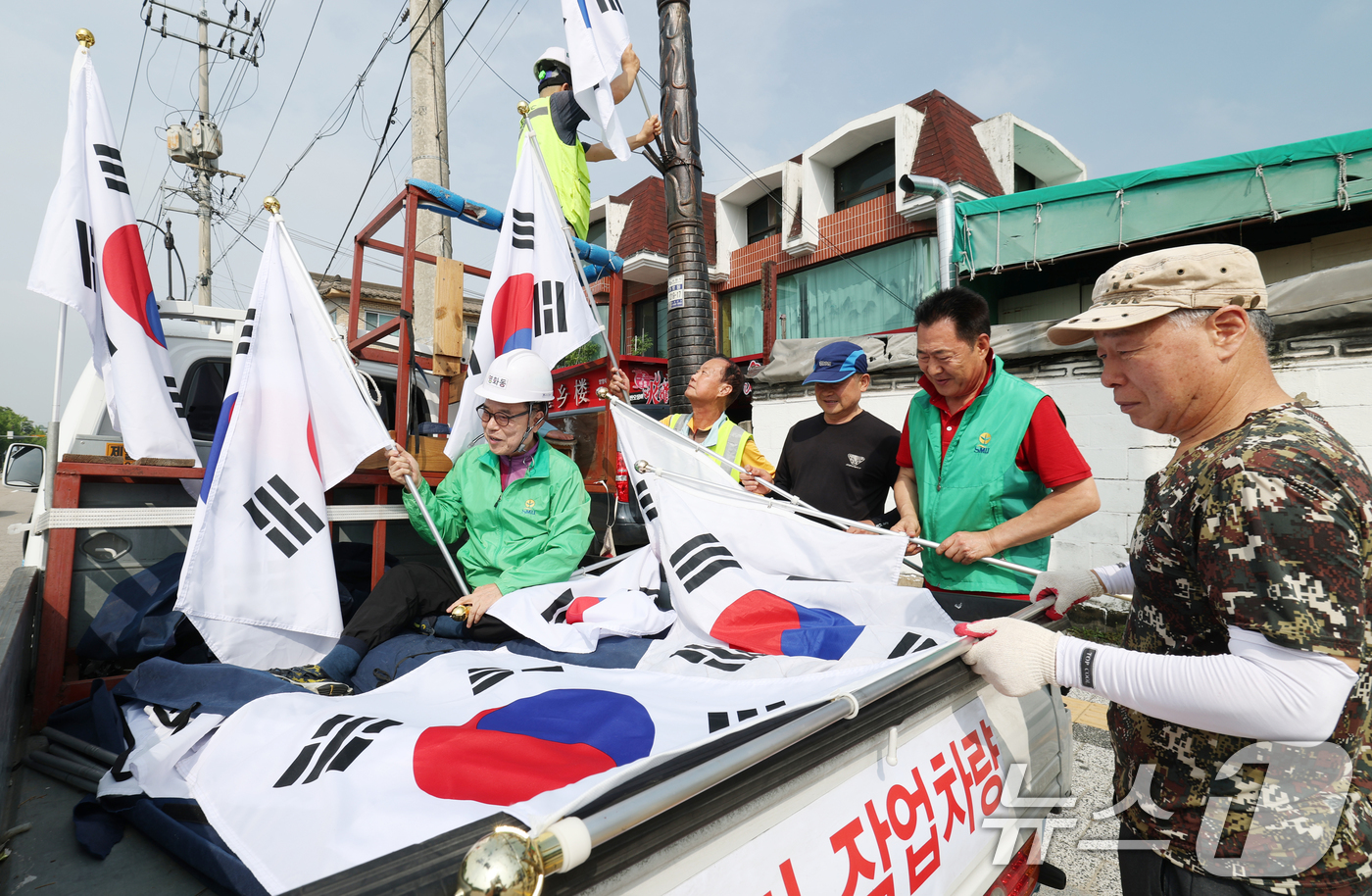 (수원=뉴스1) 김영운 기자 = 제78주년 제헌절을 하루 앞둔 16일 경기 수원시 장안구 관내에서 영화동 새마을지도자협의회 회원들이 태극기를 게양하고 있다.이날 게양한 태극기는 장 …