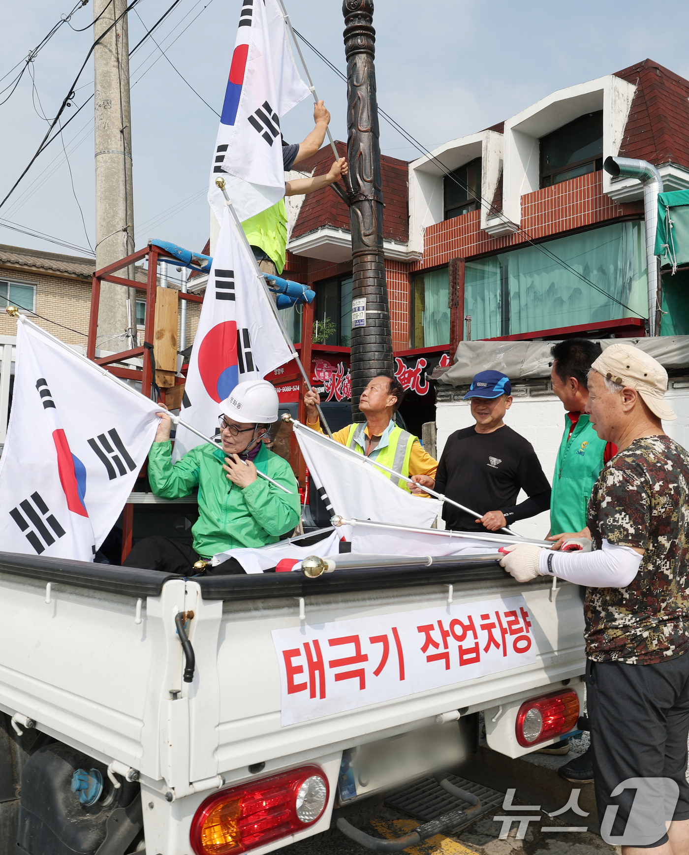 (수원=뉴스1) 김영운 기자 = 제78주년 제헌절을 하루 앞둔 16일 경기 수원시 장안구 관내에서 영화동 새마을지도자협의회 회원들이 태극기를 게양하고 있다.이날 게양한 태극기는 장 …