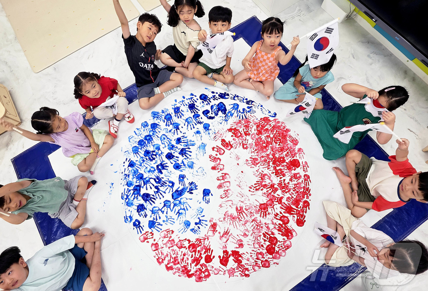 (전남광주=뉴스1) = 대한민국 헌법 공포를 기념하는 제헌절 78주년을 하루 앞둔 16일 전남광주통합특별시 북구청직장어린이집에서 아이들이 손도장을 찍어 완성한 태극 문양 앞에서 태 …