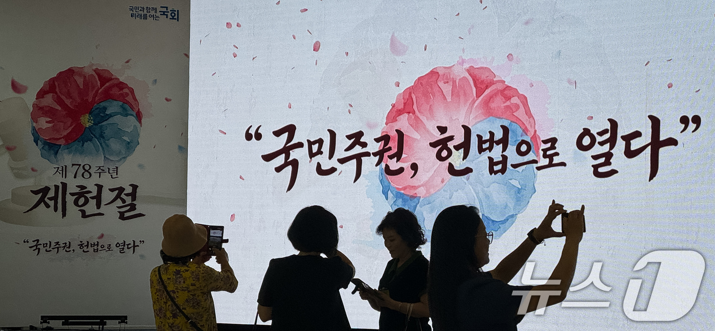 (서울=뉴스1) 유승관 기자 = 제78주년 제헌절을 하루 앞둔 16일 서울 여의도 국회를 찾은 참관객들이 로텐더홀에 마련중인 경축식 행사장을 배경으로 기념 촬영을 하고 있다. 20 …