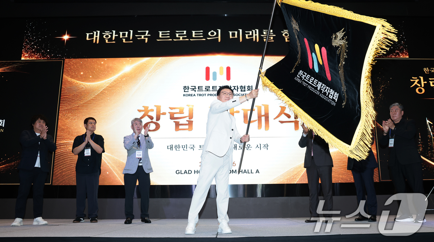 (서울=뉴스1) 권현진 기자 = 시성웅 회장이 16일 서울 영등포구 글래드호텔에서 열린 한국트로트제작자협회 창립 발대식에 참석해 협회기를 힘차게 흔들고 있다.‘한국트로트제작자협회’ …
