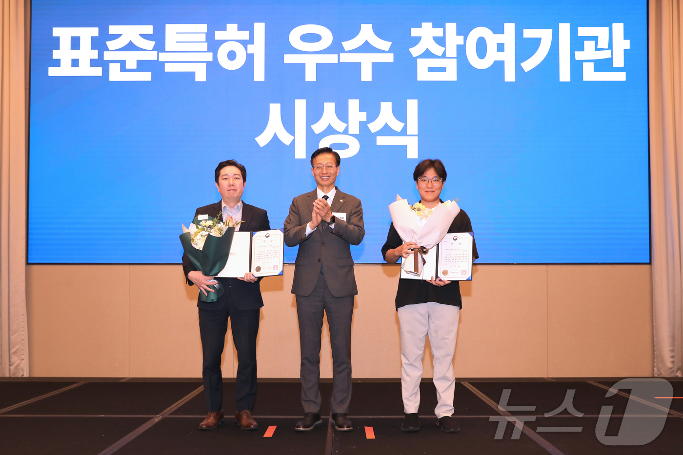 (서울=뉴스1) = 김용선 지식재산처장이 16일 오후 서울 강남구 조선팰리스 더그레이트홀에서 열린 2026년 표준특허 전략 확산 컨퍼런스에서 수상자 대표인 류창우 가온그룹 팀장(왼 …