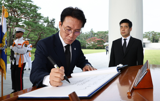 참배 마치고 방명록 작성하는 김민석 전 총리