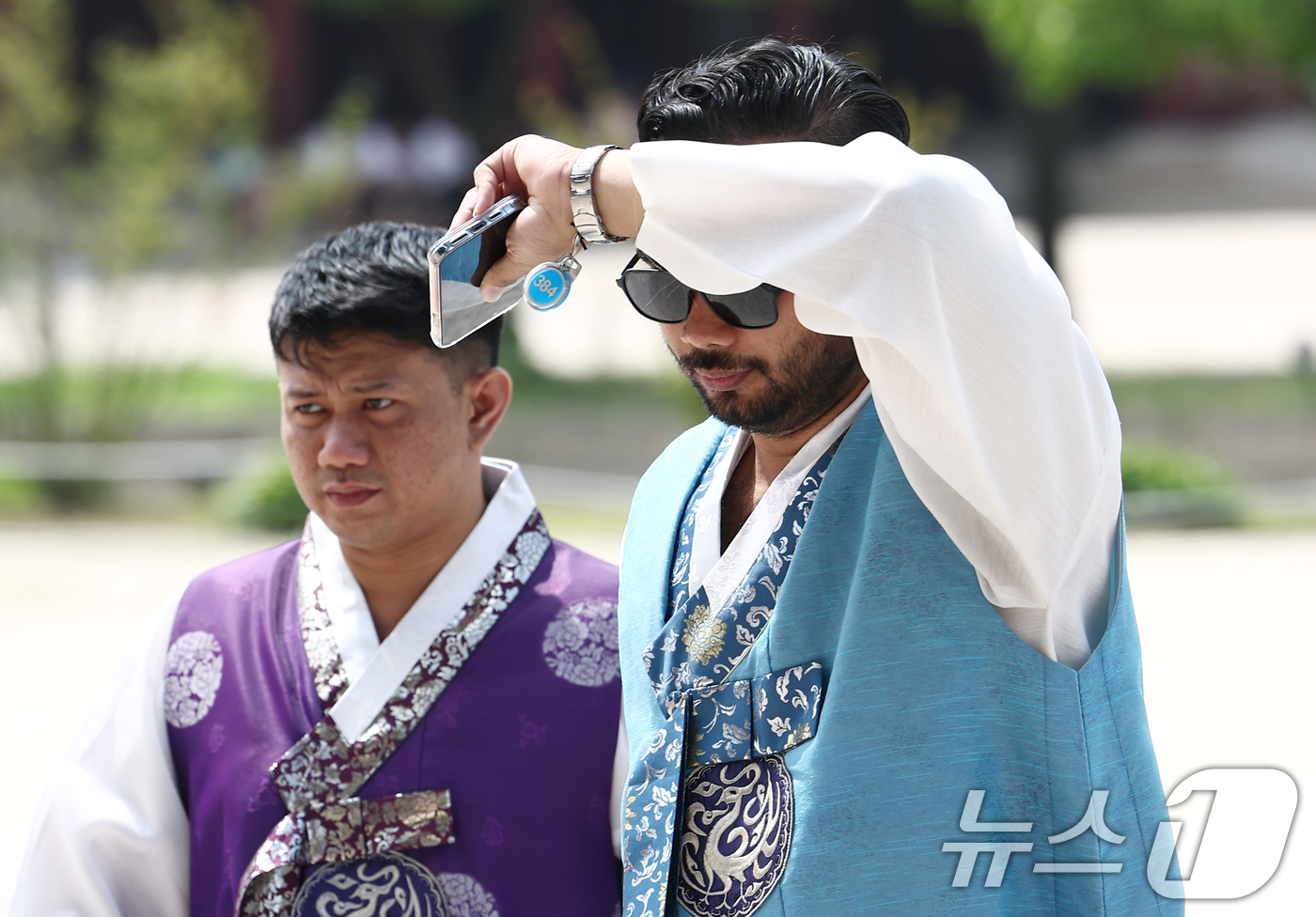 (서울=뉴스1) 김민지 기자 = 전국 대부분 지역의 체감온도가 30도를 넘기며 무더운 날씨가 이어진 17일 오전 서울 종로구 경복궁에서 외국인 관광객이 팔로 햇빛을 가리며 발걸음을 …