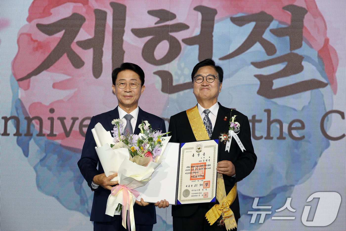 (서울=뉴스1) 국회사진기자단 = 조정식 국회의장이 17일 서울 여의도 국회에서 열린 제78회 제헌철 경축식에서 우원식 전 국회의장에게 무궁화장을 전수한 뒤 기념 촬영을 하고 있다 …
