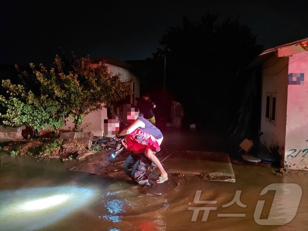 본문 이미지 - 17일 오후 8시 13분께 경북 구미시의 한 주택이 침수돼 60대 여성이 구조대원의 도움을 받아 대피하고 있다. 당시 함께 있던 다른 구조자 3명은 자력으로 탈출했다. (경북소방본부 제공. 재판매 및 DB 금지) ⓒ 뉴스1 이성덕 기자
