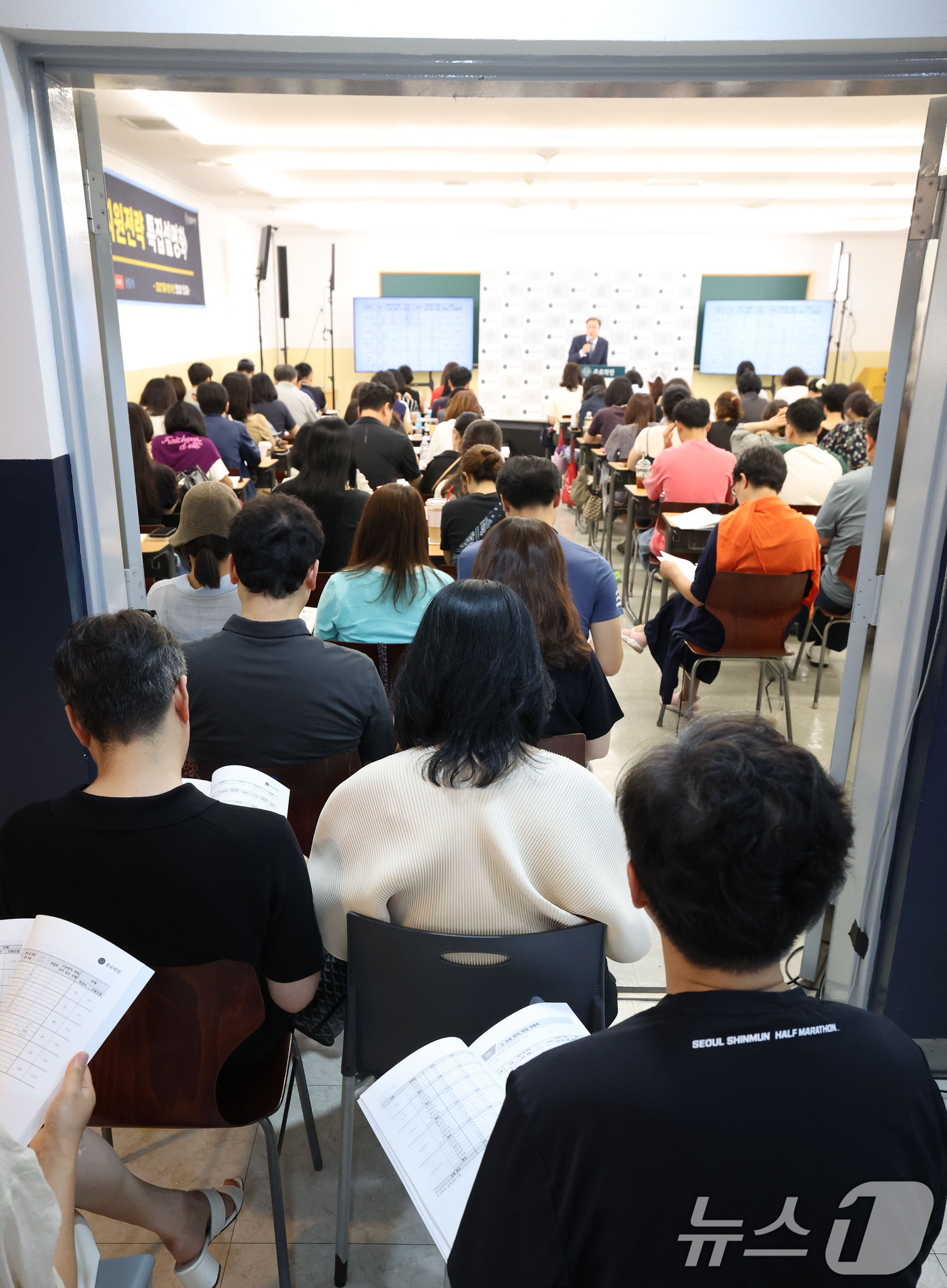 (서울=뉴스1) 이종수 기자 = 19일 서울 강남구 대치동 강남종로학원에서 열린 ‘2027 수시·정시 대학 선택전략 특집 설명회’를 찾은 학부모들이 강연장 밖에 앉아 강의를 듣고 …