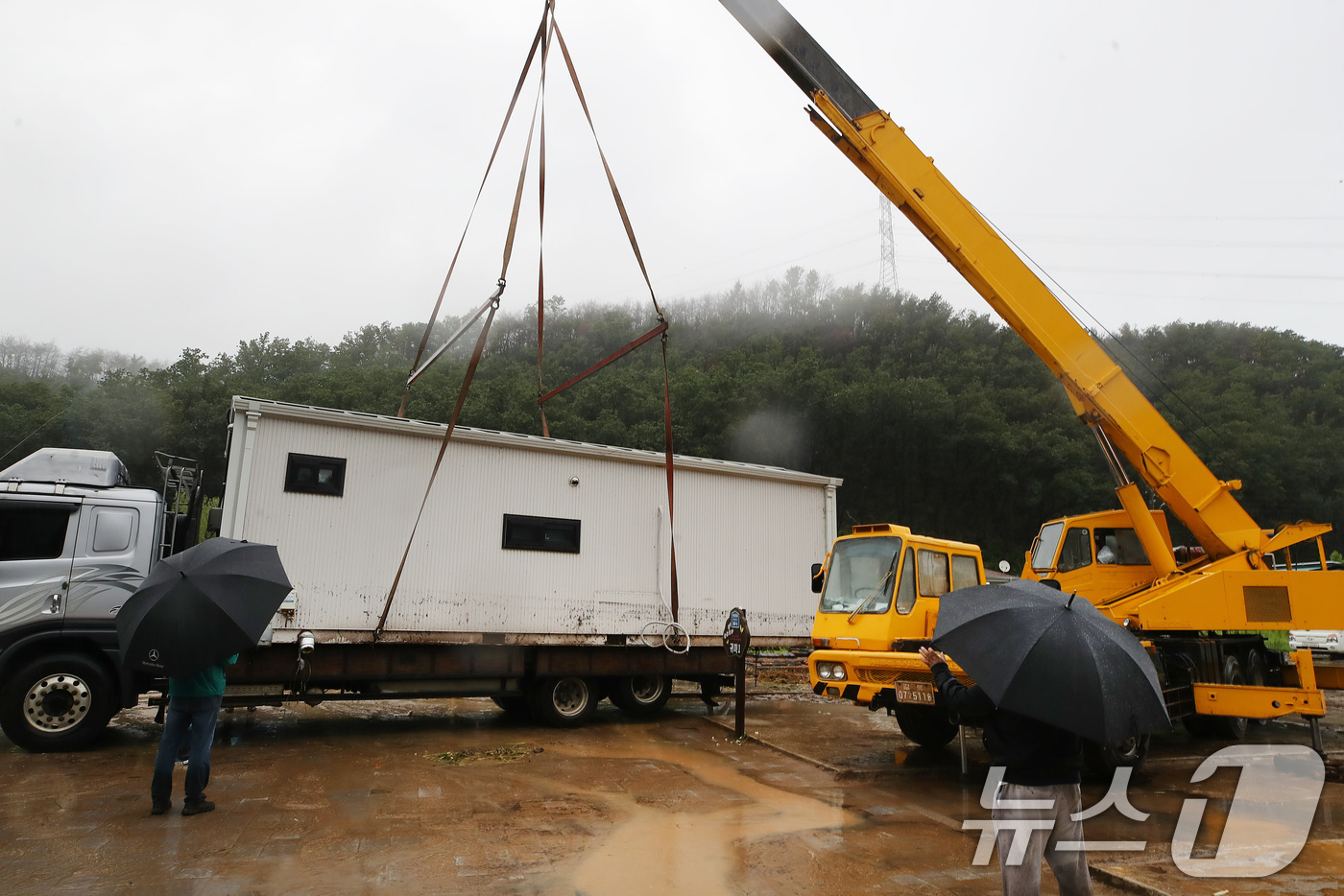 (안동=뉴스1) 공정식 기자 = 19일 경북 안동시 일직면 귀미리 산불 이재민 주거용 임시 주택 일대가 집중호우로 침수된 가운데 수해 복구 현장에 다시 폭우가 쏟아지자 크레인과 트 …