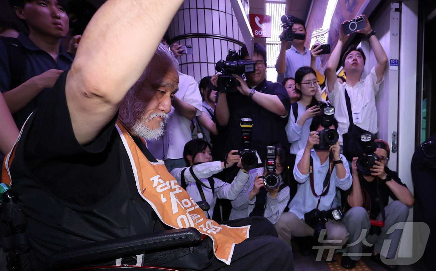 (서울=뉴스1) 김성진 기자 = 전국장애인차별철폐연대(전장연) 박경석 대표를 비롯한 소속 회원들이 2일 오전 서울 중구 지하철 1호선 시청역에서 '69차 출근길 지하철 탑니다' 탑 …