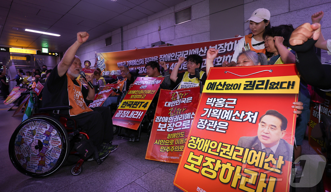 (서울=뉴스1) 김성진 기자 = 전국장애인차별철폐연대(전장연) 박경석 대표를 비롯한 소속 회원들이 2일 오전 서울 중구 지하철 1호선 시청역에서 '69차 출근길 지하철 탑니다' 탑 …