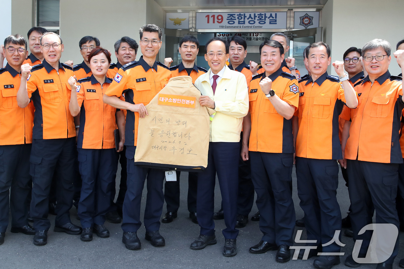 (대구=뉴스1) 공정식 기자 = 추경호 대구시장이 2일 오전 대구소방안전본부를 찾아 소방관 격려 메시지를 적은 방화복을 들고 기념촬영을 하고 있다. 2026.7.2/뉴스1