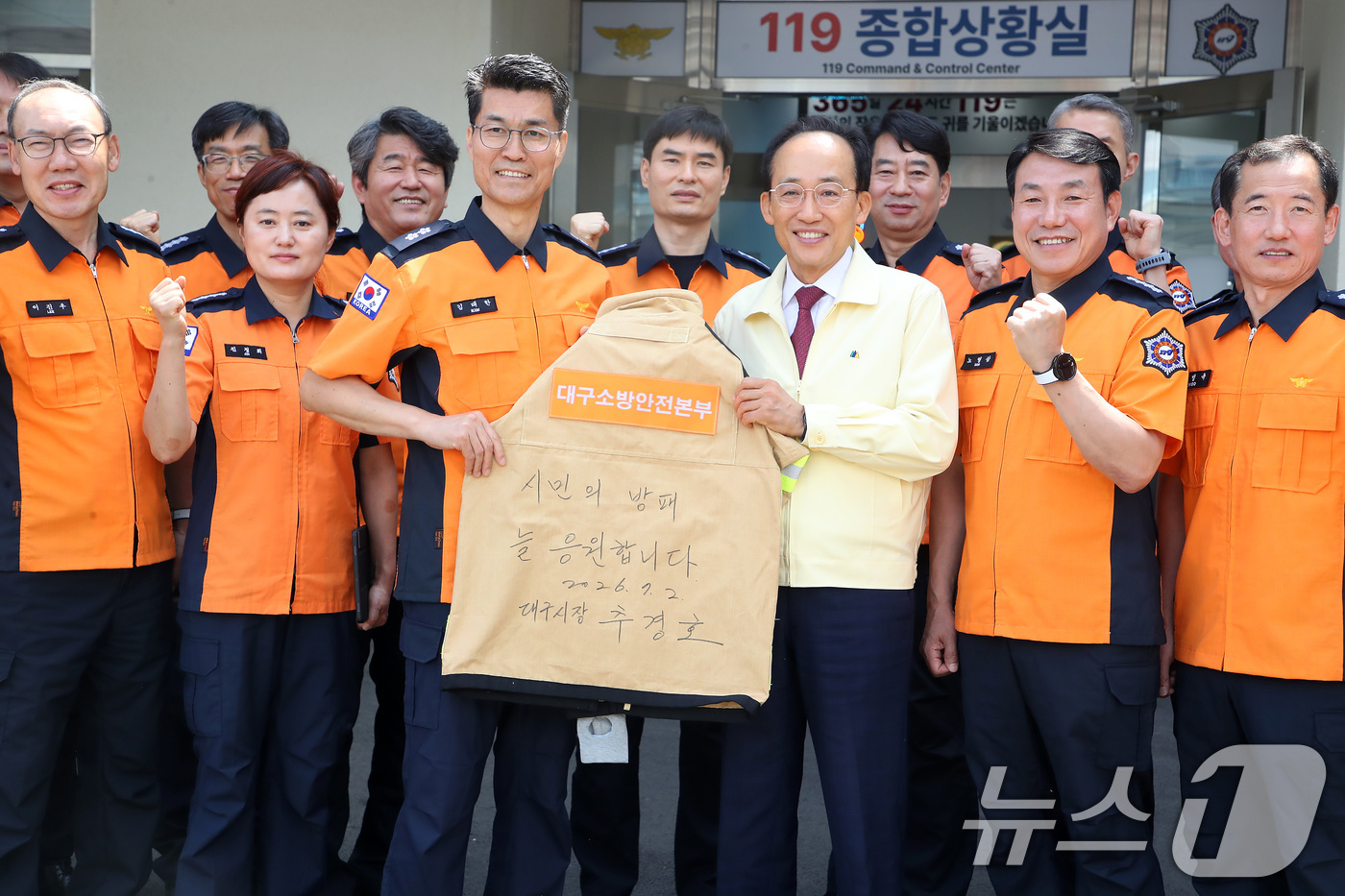 (대구=뉴스1) 공정식 기자 = 추경호 대구시장이 2일 오전 대구소방안전본부를 찾아 소방관 격려 메시지를 적은 방화복을 들고 기념촬영을 하고 있다. 2026.7.2/뉴스1