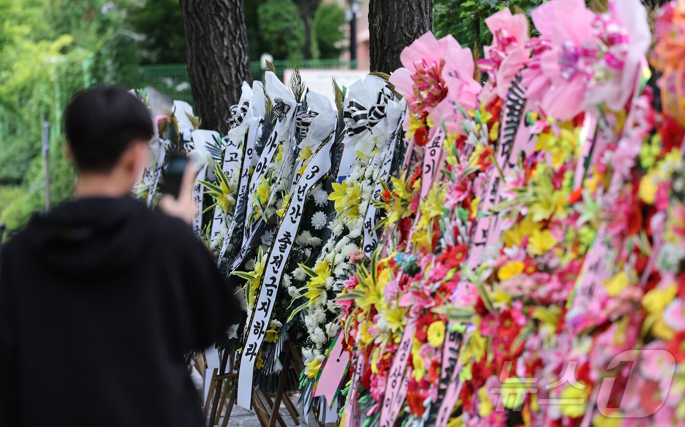 본문 이미지 - 2일 서울 강동구 배재고등학교 앞에 배재고등학교 야구부를 비판하는 근조화환과 응원하는 화환이 놓여 있다. 2026.7.2 ⓒ 뉴스1 김성진 기자