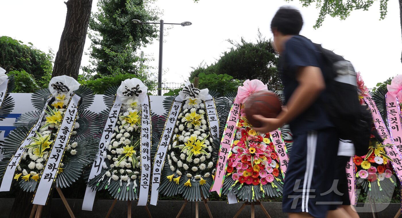 본문 이미지 - 2일 서울 강동구 배재고등학교 앞에 배재고등학교 야구부를 비판하는 근조화환과 응원하는 화환이 놓여 있다. 2026.7.2 ⓒ 뉴스1 김성진 기자