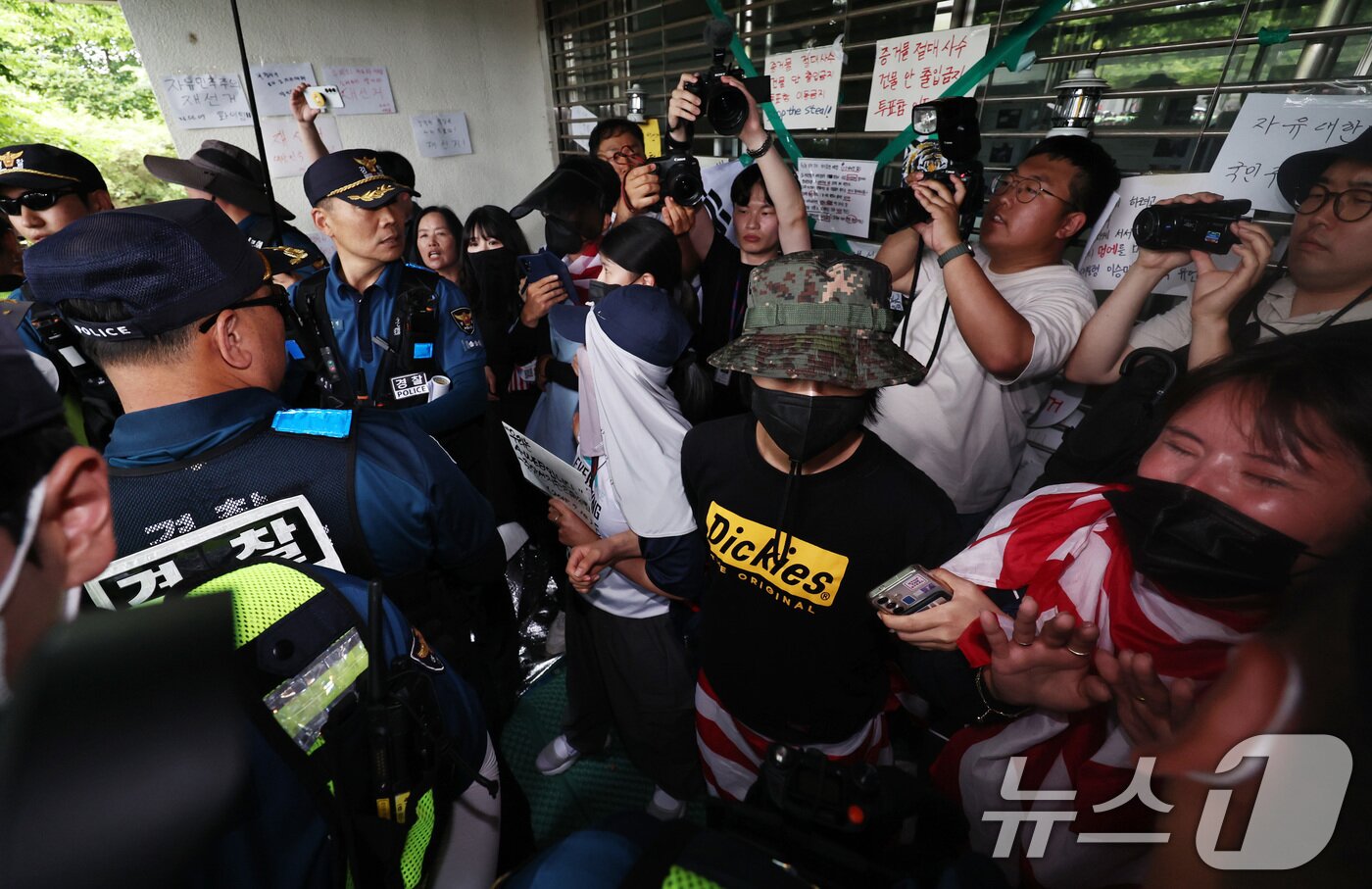 본문 이미지 - 2일 오후 국정조사특별위원회의 개표소 현장조사를 앞둔 서울 송파구 올림픽공원 핸드볼경기장에서 시위 참가자들이 스크럼을 짜며 출입구를 막아서자 경찰이 강제해산을 시도하고 있다. 2026.7.2 ⓒ 뉴스1 구윤성 기자