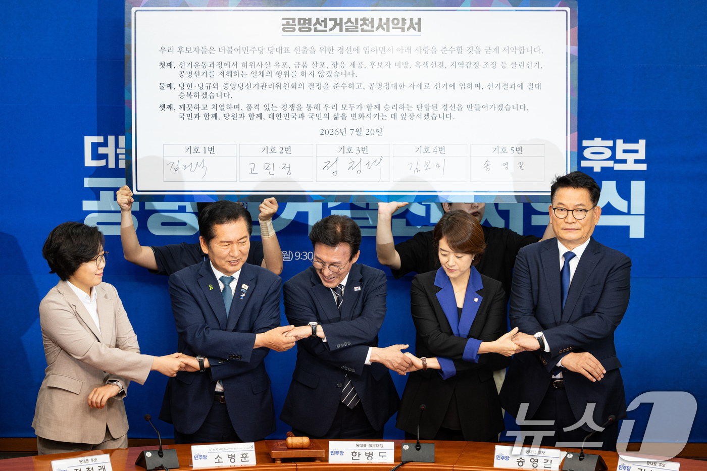 (서울=뉴스1) 유승관 기자 = 더불어민주당 8·17 전당대회 당대표 후보들이 20일 서울 여의도 국회에서 열린 공명선거 실천 서약식에서 서약서에 서명 후 손을 맞잡고 있다.왼쪽부 …