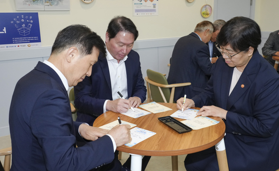 희망 메시지 적는 정은경 장관과 최태원 회장