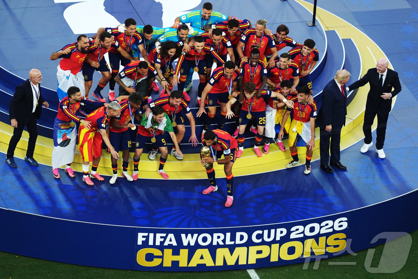 본문 이미지 - 도널드 트럼프 미국 대통령과 잔니 인판티노 국제축구연맹(FIFA·피파) 회장이 지난 2026년 7월 19일 미국 뉴저지주 이스트러더퍼드의 뉴욕 뉴저지 스타디움에서 열린 2026 FIFA 월드컵 결승전 스페인 대 아르헨티나의 경기 종료 후, 월드컵 우승을 차지한 스페인 선수들이 트로피를 들고 자축하는 모습을 바라보고 있다. 2026.7.19. ⓒ 로이터=뉴스1