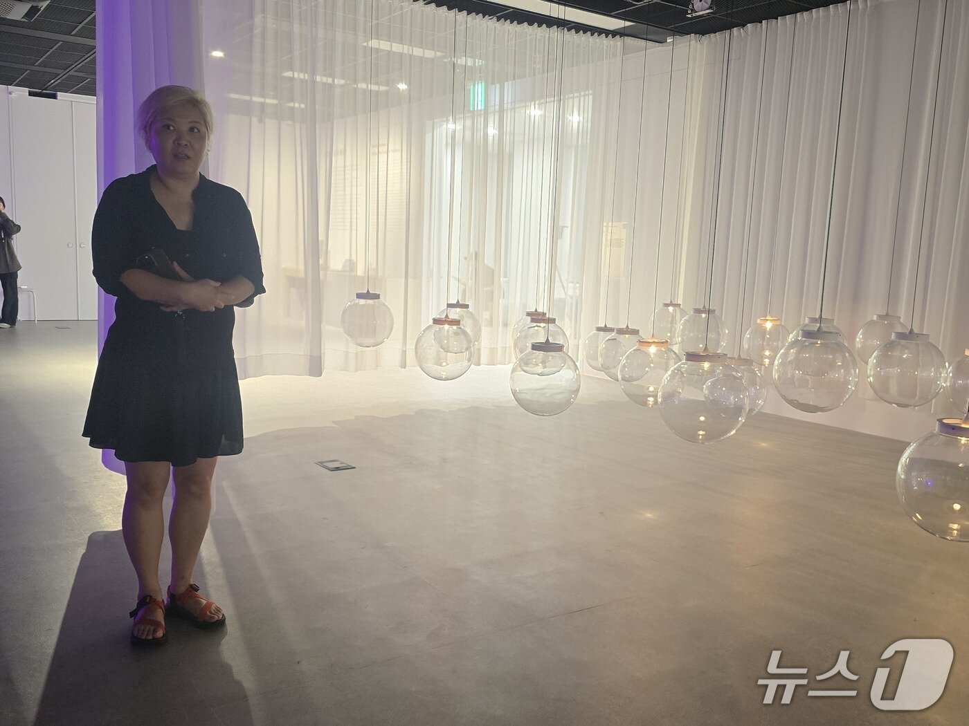 본문 이미지 - 20일 기자간담회가 진행된 '미디어 술래'전 전시 전경. 박은영 작가가 투명 구체의 인터랙티브 작품을 선보이고 있다. ⓒ 뉴스1 김정한 기자