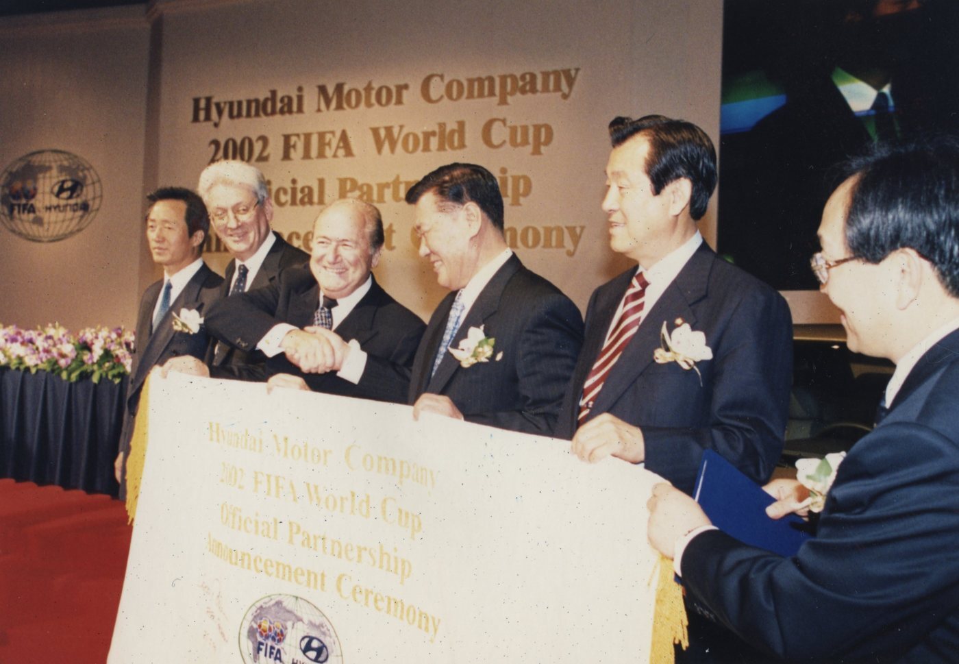 본문 이미지 - 1999년 열린 2002 FIFA 월드컵 공식 파트너십 발표 행사에서 현대자동차그룹 정몽구 명예회장(오른쪽에서 세 번째) 등 관계자들이 기념 촬영을 한 모습(자료사진. 현대차그룹 제공). 2026.7.21.