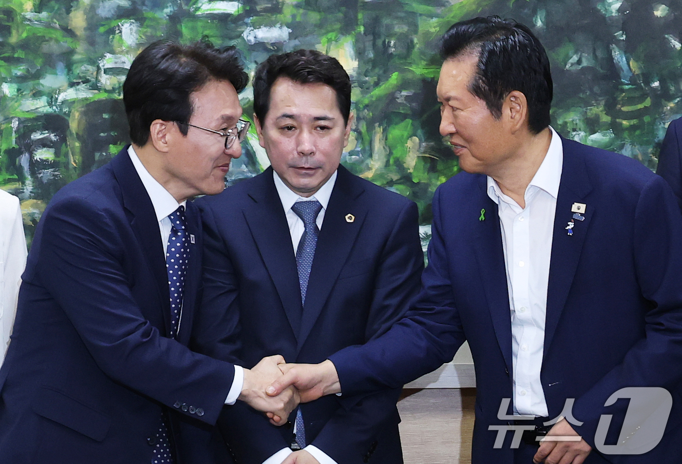 (서울=뉴스1) 오대일 기자 = 더불어민주당 당권에 도전하는 김민석, 정청래 후보가 21일 서울 중구 서울시의회에서 열린 당대표 후보자 초청 간담회에 앞서 악수를 나누고 있다. 가 …