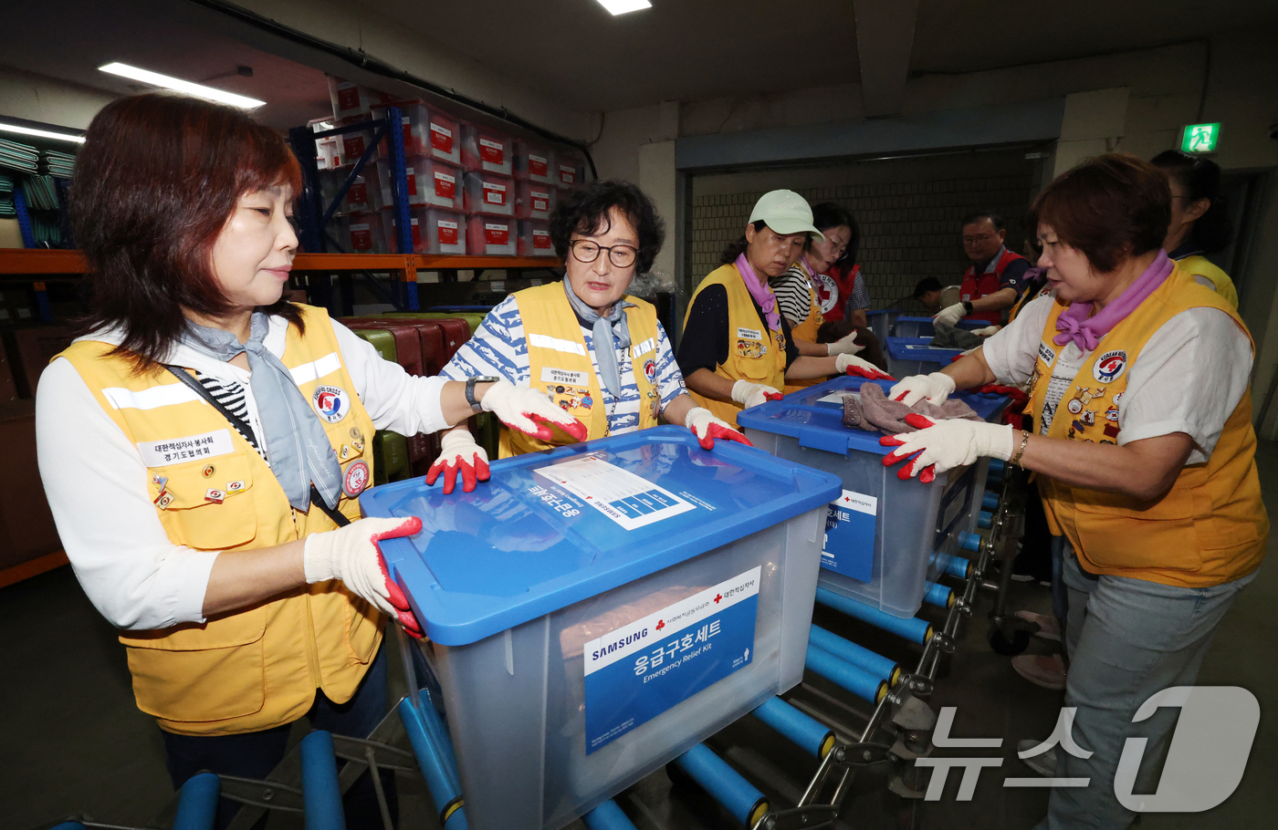 (수원=뉴스1) 김영운 기자 = 21일 경기 수원시 권선구 대한적십자사 경기도지사에서 자원봉사자들이 2026년 응급구호세트 1차분을 옮기고 있다.이날 입고된 응급구호세트 총 500 …